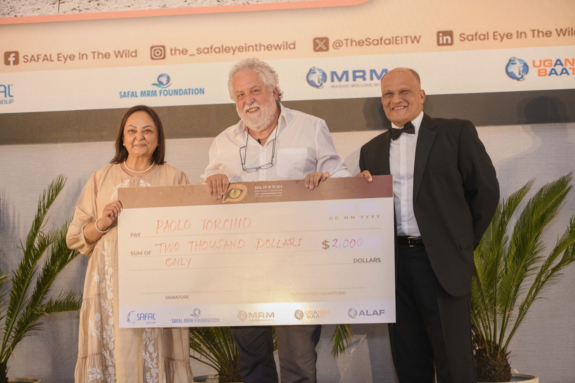 Paolo Torchio receiving a US$2,000 cheque from Safal MRM Foundation trustees at the SEIW gala.