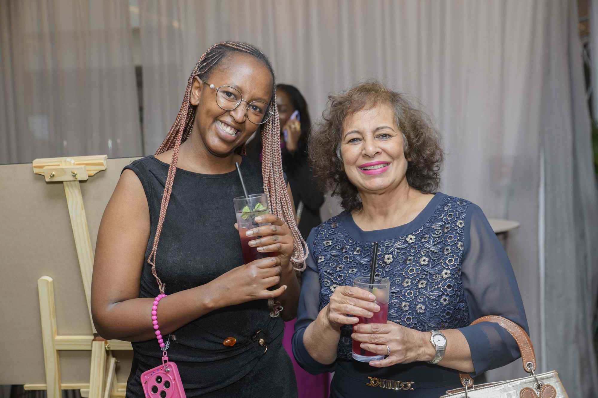 Two Safal guests smiling with drinks at a Safal Group networking reception.