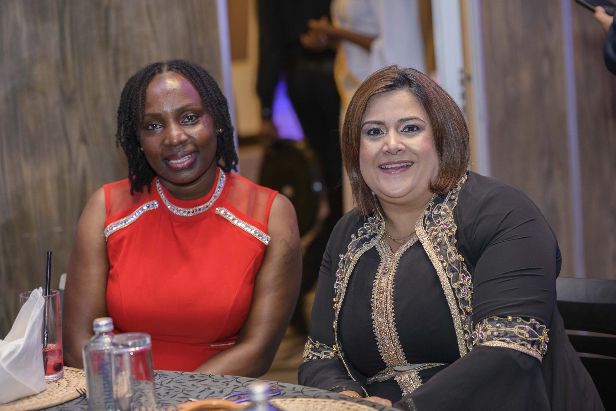 Two Safal colleagues in evening wear seated together at a Safal Group celebration.