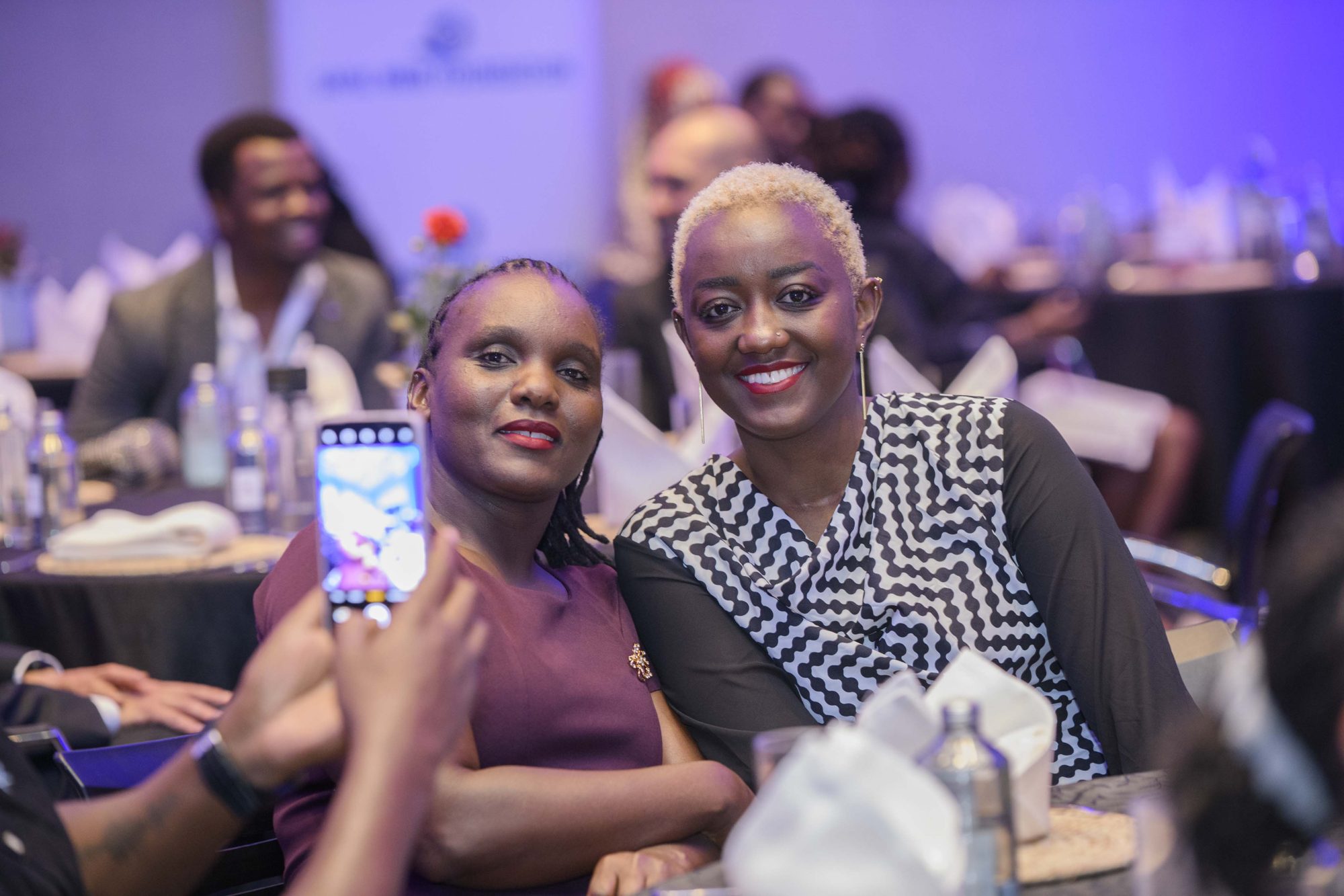 Two Safal colleagues smiling and taking a photo together at a group gala dinner.
