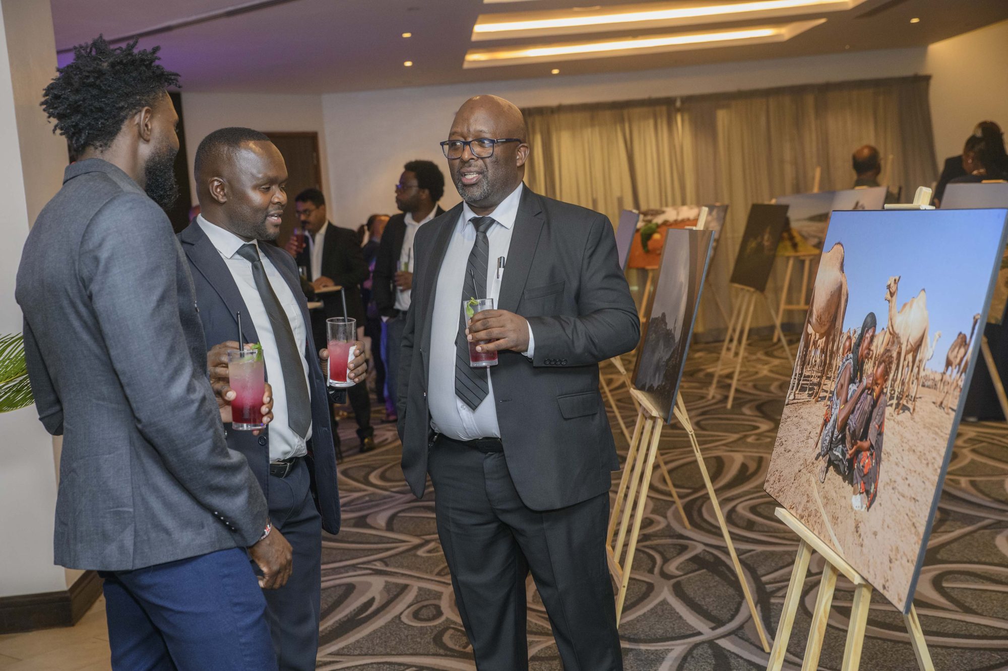 Safal leaders and guests networking among the exhibition easels.